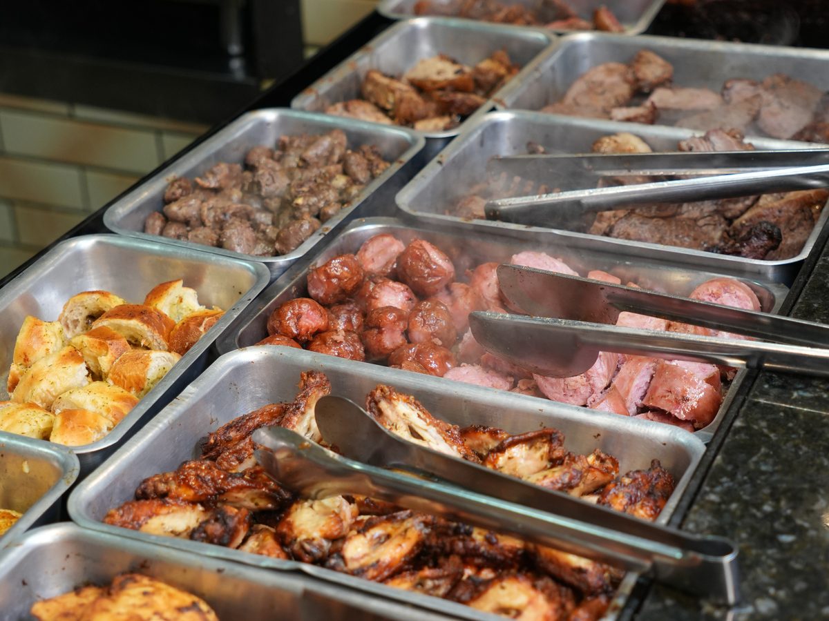 Bandejas de carnes grelhadas do buffet: linguiça, coração, frango e mais.